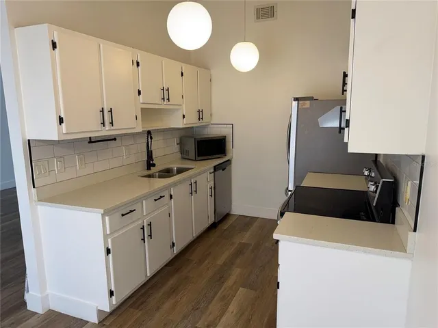 a kitchen with cabinets appliances and a sink