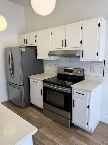 a kitchen with stainless steel appliances a refrigerator stove and cabinets