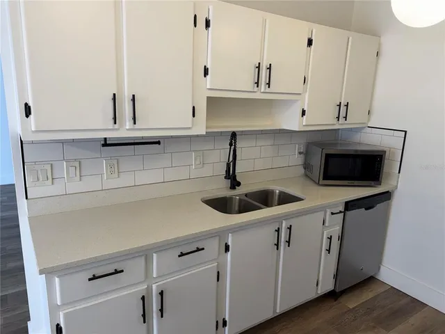 a kitchen with stainless steel appliances white cabinets and a sink
