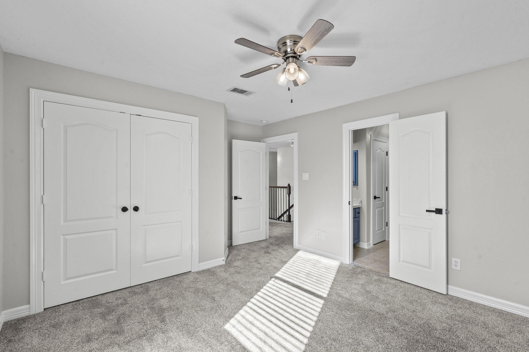 2730 Lawrence Road Kemah, TX 77565 - Photo 40 of 46 This is a bright, carpeted bedroom with neutral walls, featuring a ceiling fan, double-door closet, and access to a bathroom and hallway.