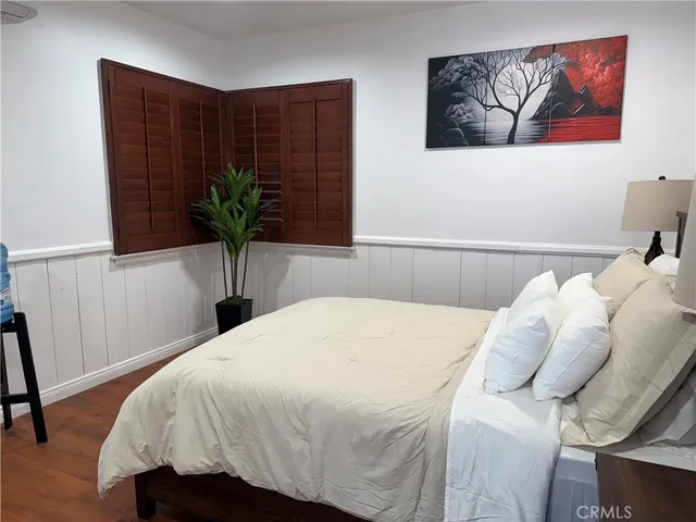 a bedroom with a bed and a potted plant