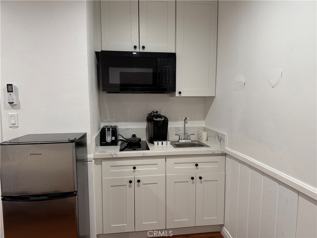 7029 Bellaire Avenue, Unit B North Hollywood, CA 91605 - Photo 3 of 3 a kitchen with stainless steel appliances a sink a stove a microwave and cabinets