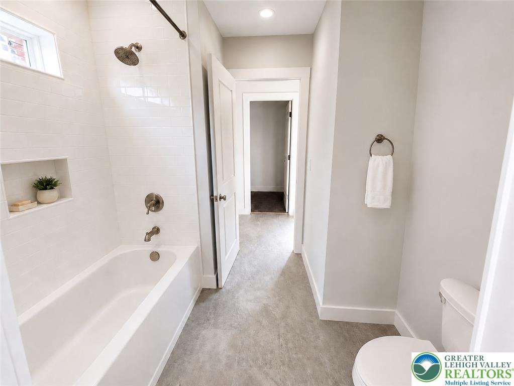 3104 Moyer Road Hellertown, PA 18055 - Photo 13 of 24 Tiled walls and a clean alcove tub frame this contemporary bathroom design.
