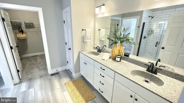 a spacious bathroom with a double vanity sink and mirror