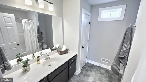 a spacious bathroom with a double vanity sink a mirror and a shower