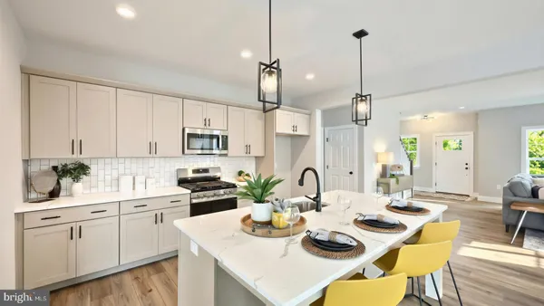 a kitchen with stainless steel appliances kitchen island granite countertop a sink a stove a dining table and chairs with wooden floor