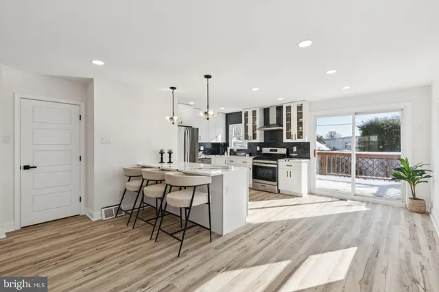 a kitchen with stainless steel appliances kitchen island granite countertop a stove a sink and a refrigerator