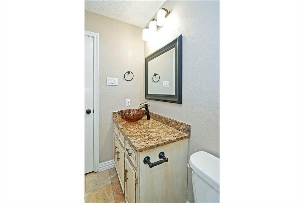2509 Country Valley Road Garland, TX 75041 - Photo 14 of 17 Half bathroom with vanity, a textured wall, and a textured ceiling