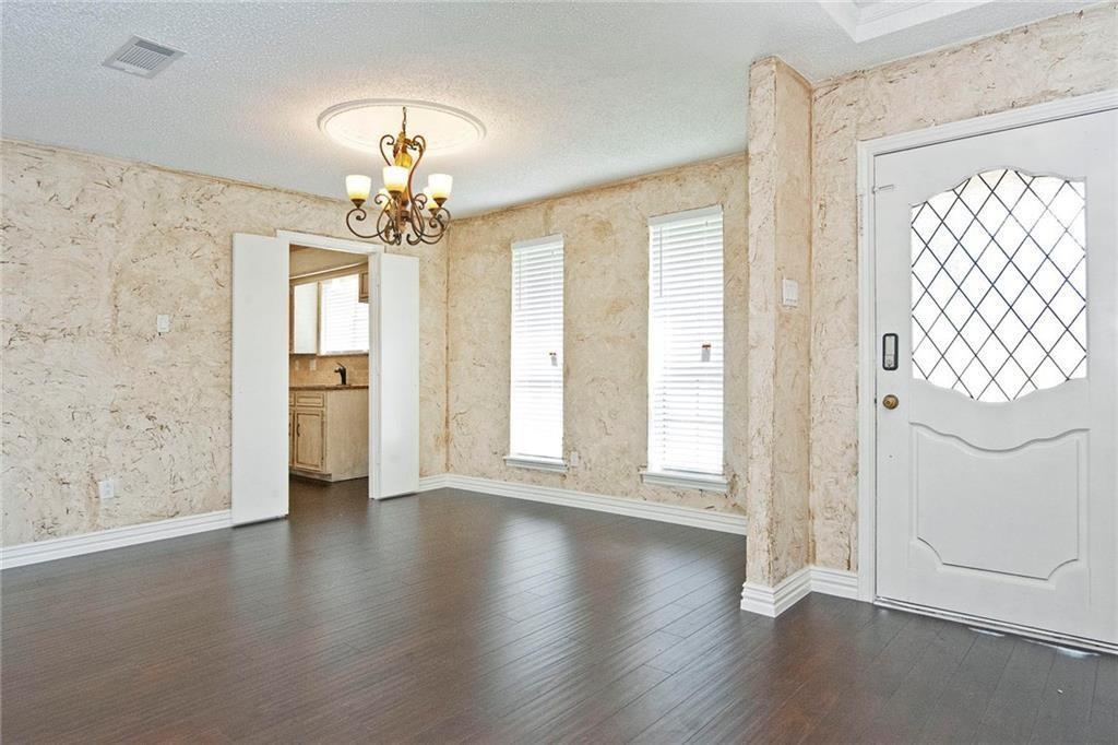 2509 Country Valley Road Garland, TX 75041 - Photo 4 of 17 Foyer entrance featuring hanging lights, a textured ceiling, healthy amount of natural light, and dark wood-style floors
