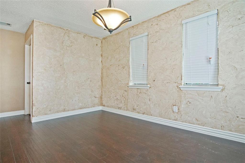 2509 Country Valley Road Garland, TX 75041 - Photo 5 of 17 Spare room featuring a textured ceiling and dark wood-style floors