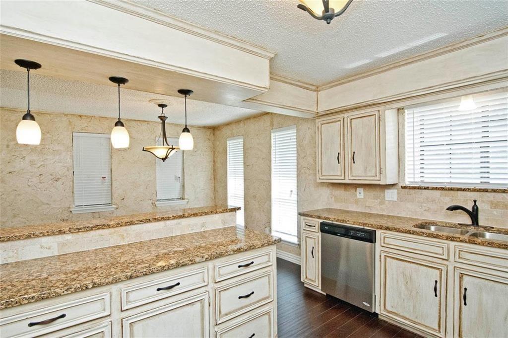 2509 Country Valley Road Garland, TX 75041 - Photo 9 of 17 Kitchen with a textured ceiling, light stone counters, pendant lighting, dishwasher, and dark wood-type flooring