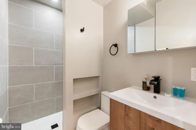 a bedroom with a bed and a lamp on the dresser