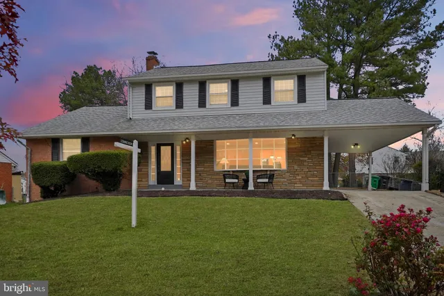 a front view of a house with a yard and green space