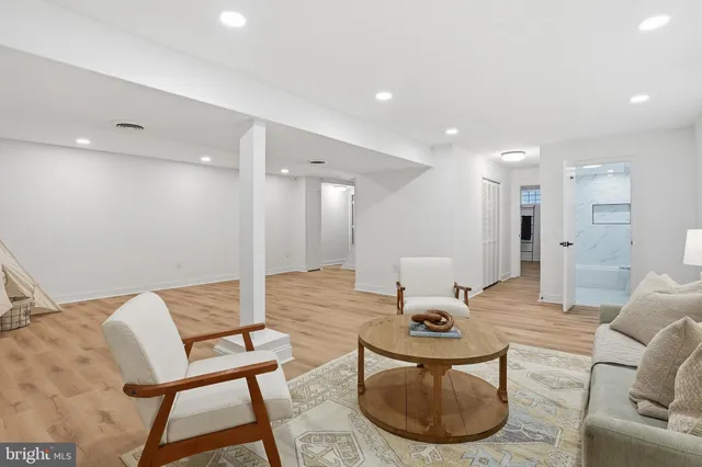 a living room with furniture a wooden floor and a chandelier