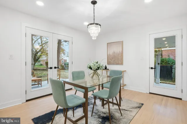 a dining room with furniture a chandelier and wooden floor