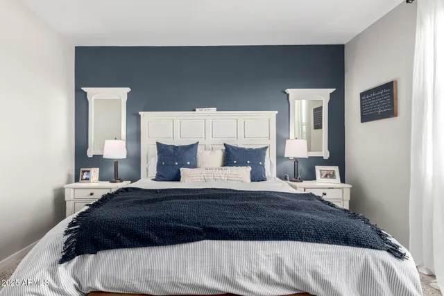 a bedroom with a bed a mirror and lamp