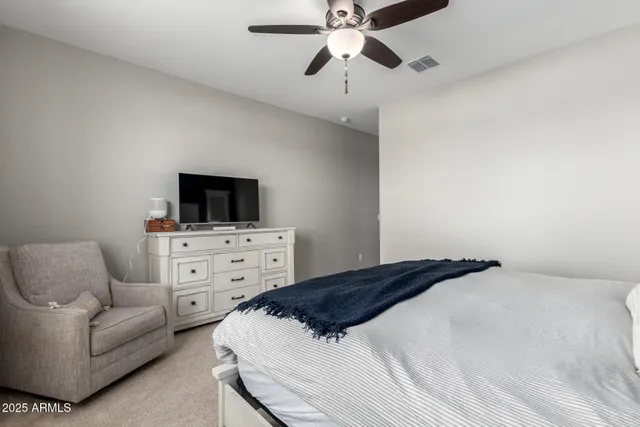 a bedroom with a bed a couch and a flat screen tv