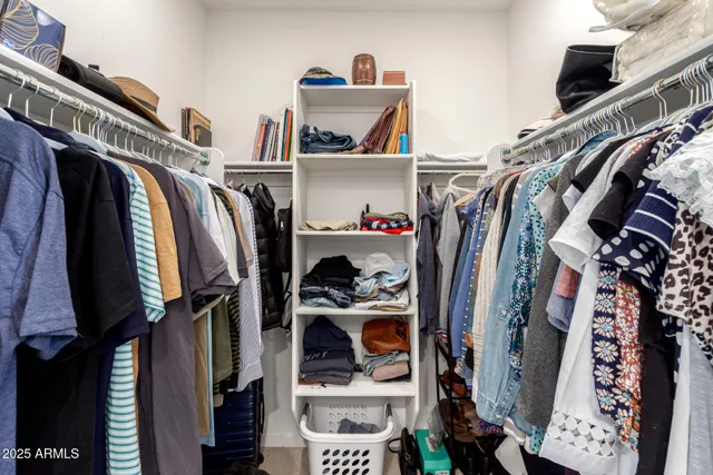 a view of walk in closet with clothes and shoes