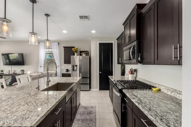 a kitchen with granite countertop a sink a counter top space appliances and cabinets