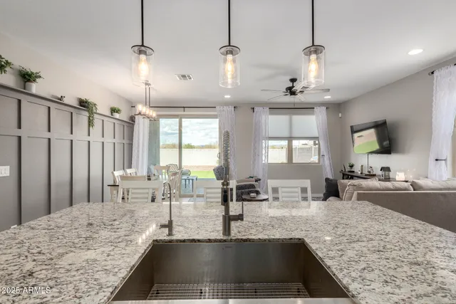 a view of a kitchen with kitchen island a large window a sink and living room view