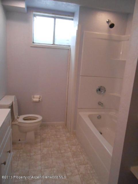 536 East 12th Street Rifle, CO 81650 - Photo 17 of 18 a bathroom with a granite countertop toilet a sink a window and shower