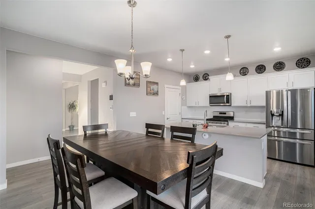 a kitchen with stainless steel appliances a dining table and chairs