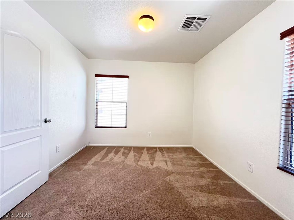 11143 Ranch Valley Street Las Vegas, NV 89179 - Photo 19 of 23 A well-lit bedroom features plush carpeting and a bright window.