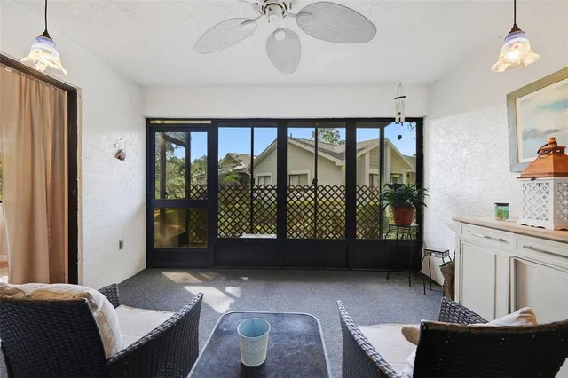 a living room with furniture and a floor to ceiling window