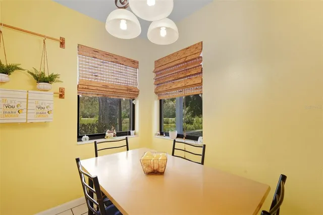 a dining room with furniture and a floor to ceiling window