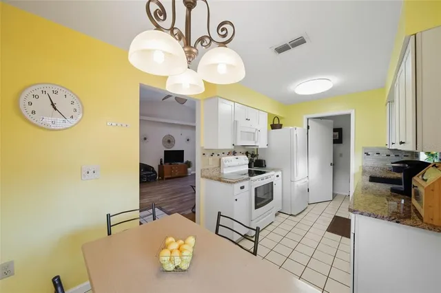 a kitchen with a sink a stove and chairs
