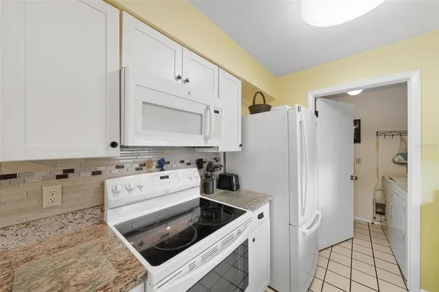 a kitchen with white cabinets and white appliances