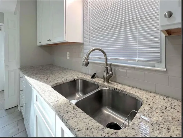 a kitchen with granite countertop a sink and a stove