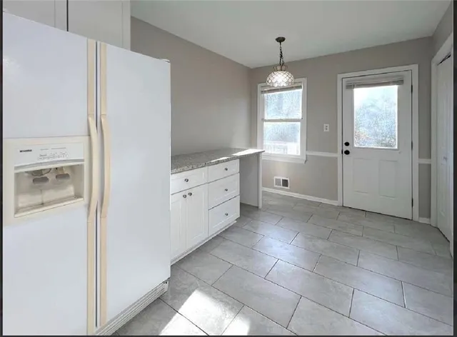 a bathroom with a granite countertop sink a toilet and a window