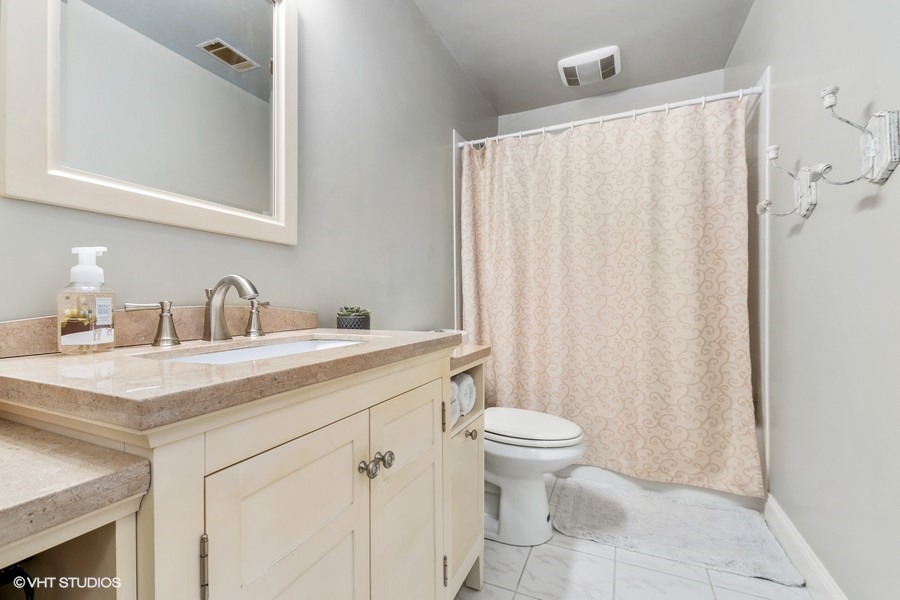11034 Bryant Road Mokena, IL 60448 - Photo 14 of 19 a bathroom with a sink a toilet and a mirror