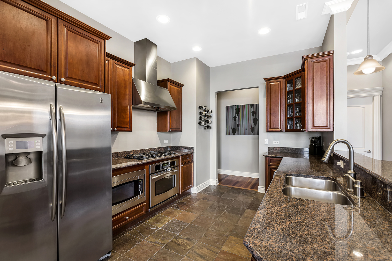 35 South Racine Avenue, Unit 4SE Chicago, IL 60607 - Photo 7 of 24 a kitchen with stainless steel appliances granite countertop a refrigerator a stove and a sink with wooden cabinets