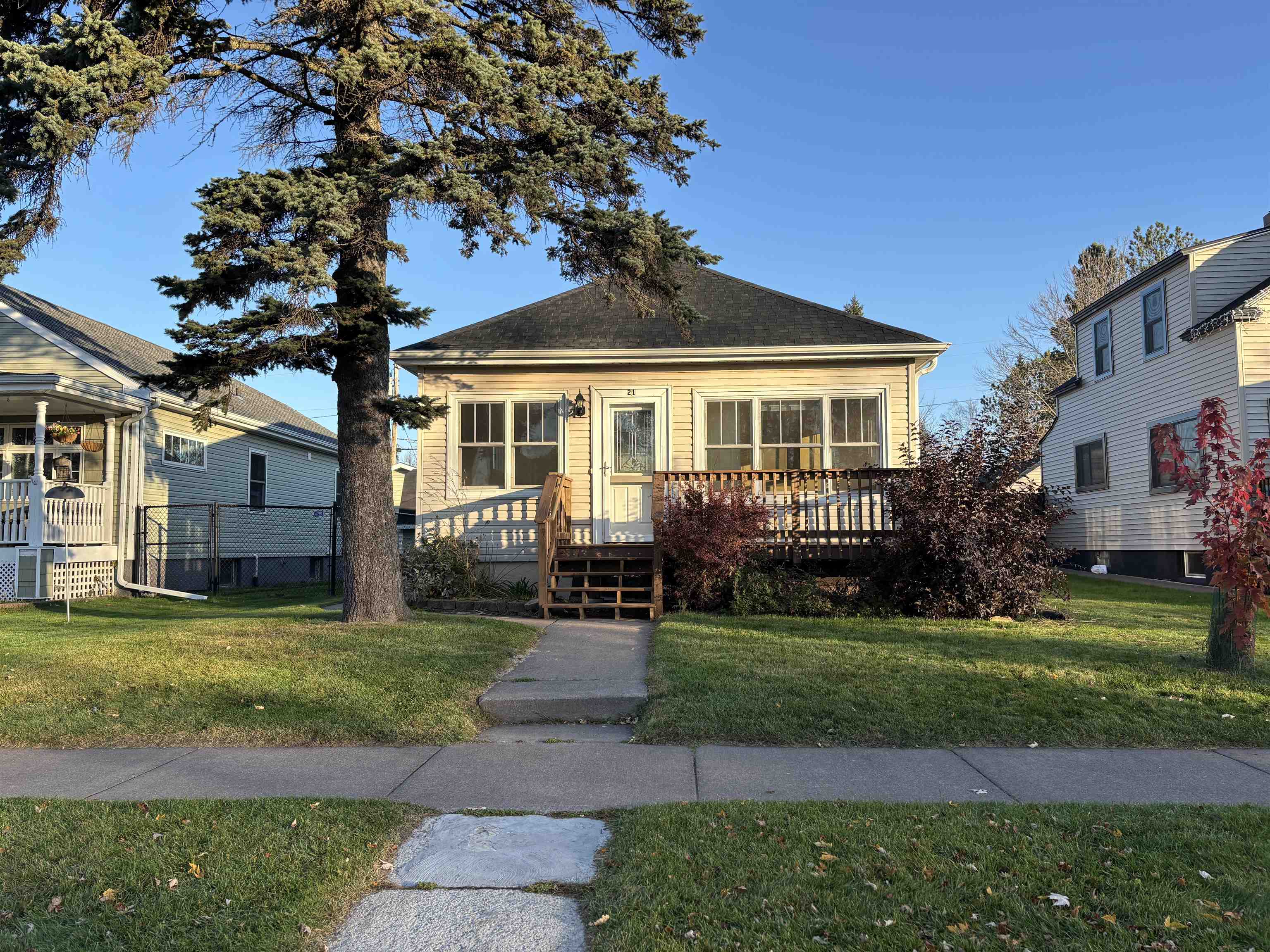 View of front of property with a front yard and a wooden deck