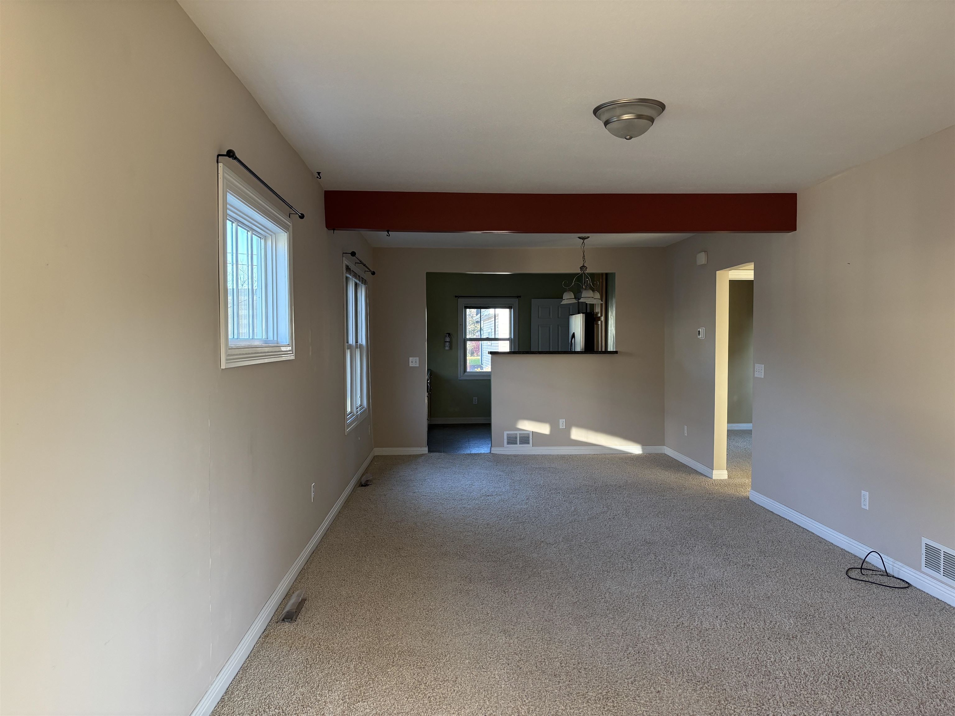 21 Oak Street Proctor, MN 55810 - Photo 8 of 26 Unfurnished living room featuring healthy amount of natural light, light colored carpet, and beamed ceiling