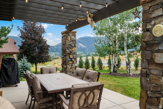4892 Eagle Rdg Drive Eden, UT 84310 - Photo 27 of 39 Covered outdoor patio featuring a concrete slab, string lighting, and stone support columns