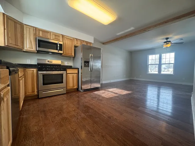 a kitchen with stainless steel appliances granite countertop a stove a sink and a refrigerator