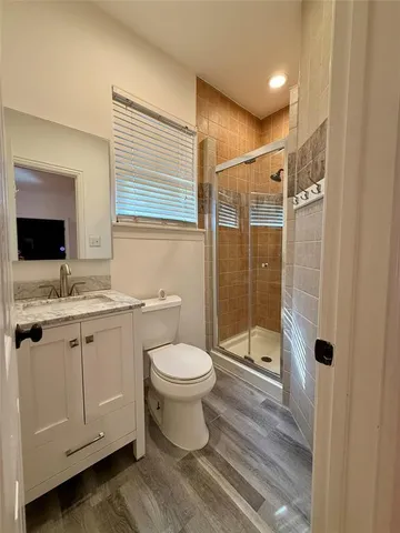 a bathroom with a granite countertop sink toilet and shower