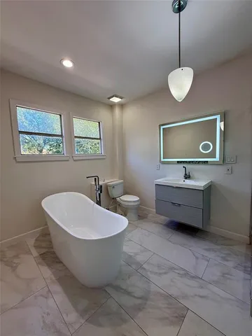 a spacious bathroom with a double vanity sink a mirror and a bathtub