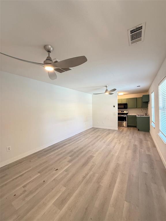 4810 Victor Street Dallas, TX 75246 - Photo 25 of 26 a view of a livingroom with a ceiling fan and wooden floor