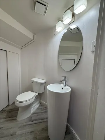 a bathroom with a toilet a sink and mirror