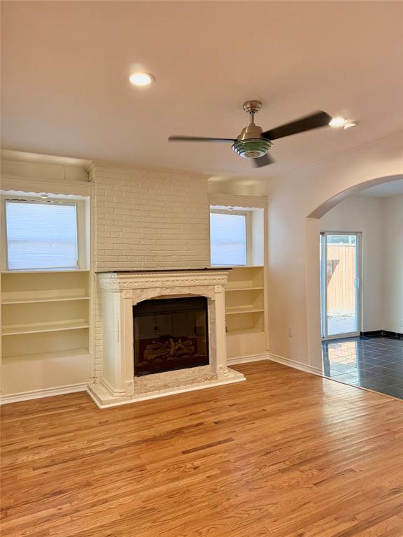 4810 Victor Street Dallas, TX 75246 - Photo 8 of 26 an empty room with wooden floor a fireplace and a window