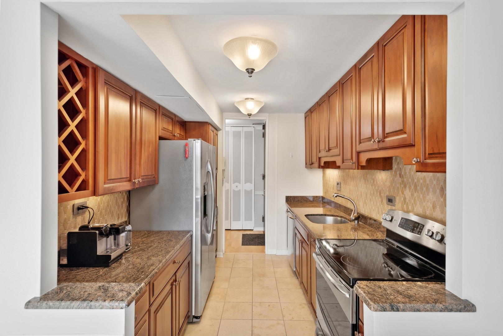 1310 North Ritchie Court, Unit 19B Chicago, IL 60610 - Photo 12 of 30 a kitchen with granite countertop wooden cabinets and a stove top oven