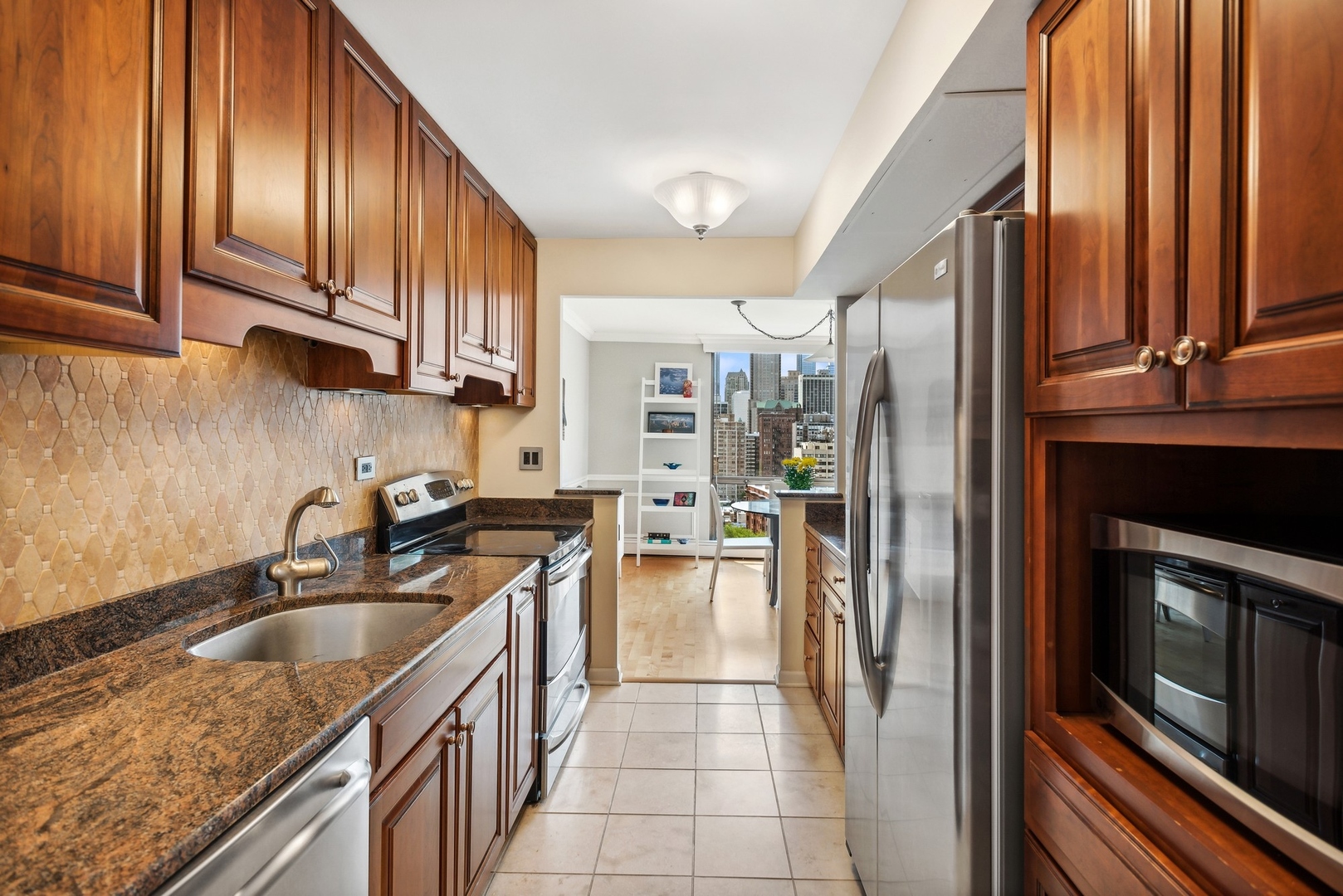 1310 North Ritchie Court, Unit 19B Chicago, IL 60610 - Photo 13 of 30 a kitchen with stainless steel appliances granite countertop a refrigerator a stove and a sink with wooden cabinets