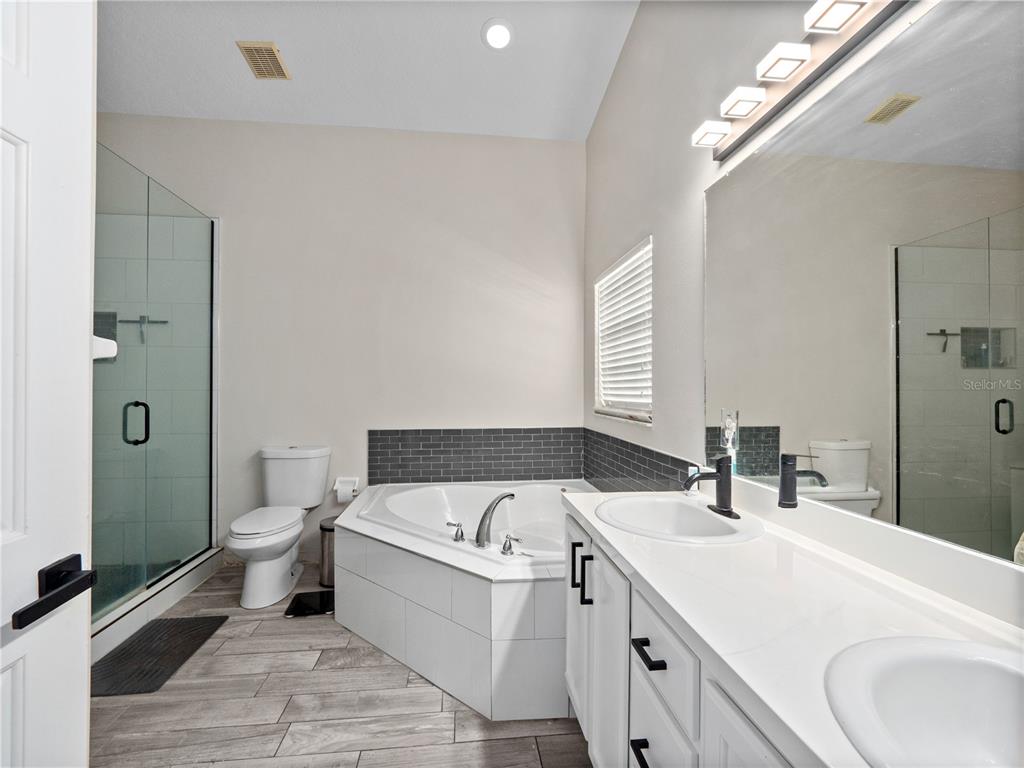 117 Rachel Lin Lane St. Cloud, FL 34771 - Photo 13 of 28 a bathroom with a double vanity sink toilet and shower