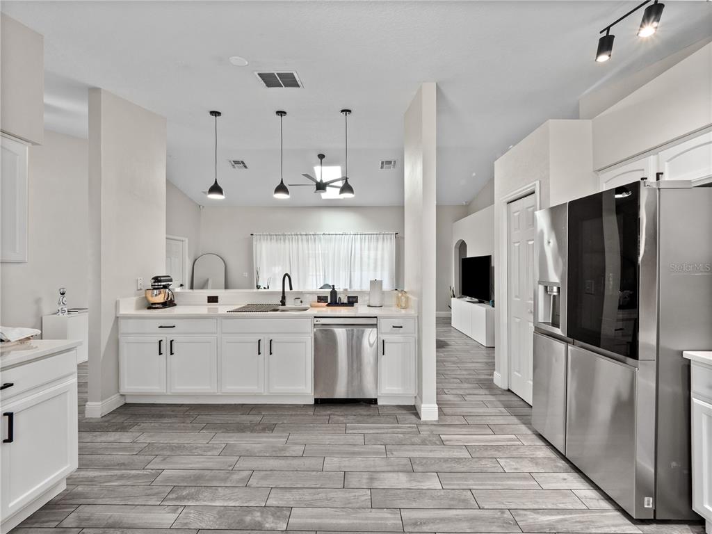 117 Rachel Lin Lane St. Cloud, FL 34771 - Photo 5 of 28 a large white kitchen with white cabinets and stainless steel appliances