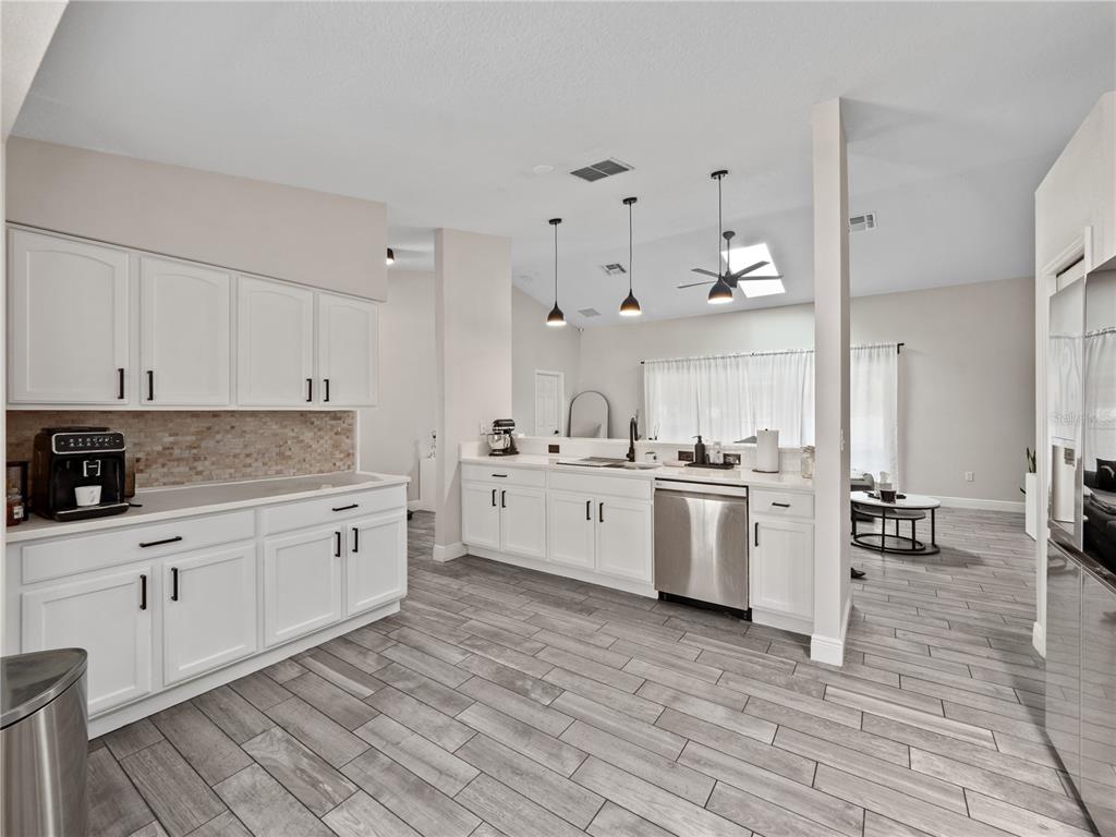 117 Rachel Lin Lane St. Cloud, FL 34771 - Photo 6 of 28 a kitchen with granite countertop a sink cabinets and wooden floor