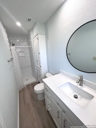 a bathroom with a double vanity sink toilet and shower